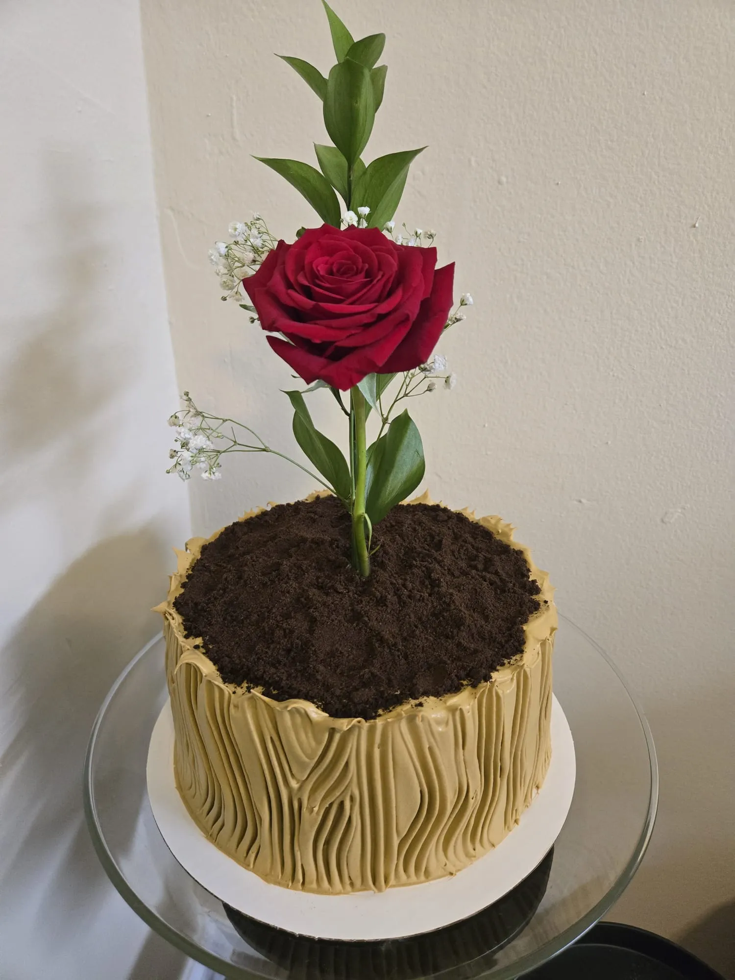 Cake tipo maceta con buttercream de tronco, tierra de galleta y rosa roja natural